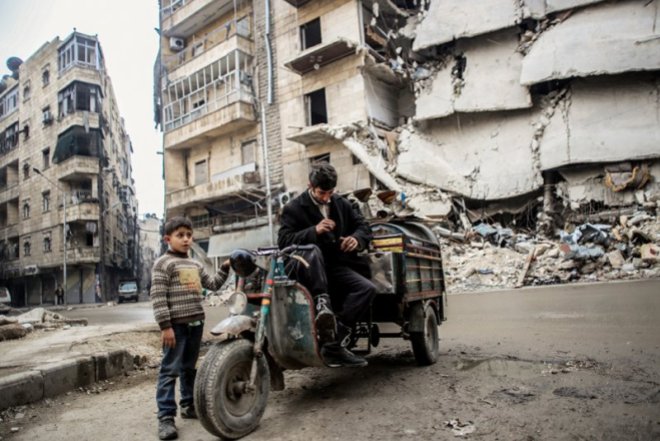 Un padre y un hijo recogen cosas de un edificio abandonado en el centro de Alepo. Miembros de Al-Qaeda se esconden en el área de Bustan al-Qaser donde se enfrentan al ejercito de al-Asad. GETTY IMAGES
