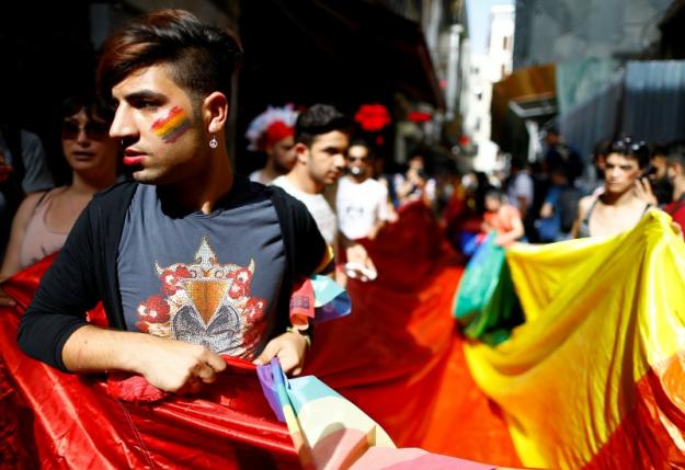 LGBT rights activists hold a rainbow flag during a transgender pride parade, which was banned by the governorship, in central Istanbul